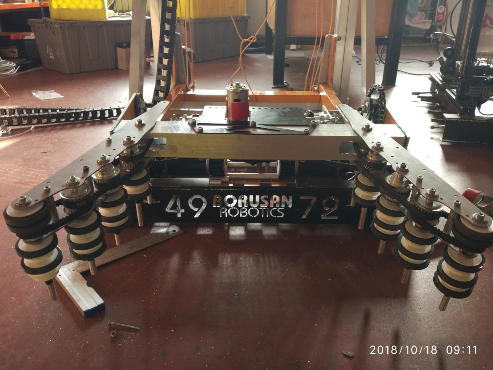 2018 robotunun alt gövdesi: iki yanda tekerlekli toplayıcı kollar, önde Borusan Robotics plakası